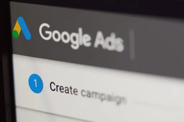 Blurred view of a computer screen displaying the Google Ads interface with the "Create campaign" option visible